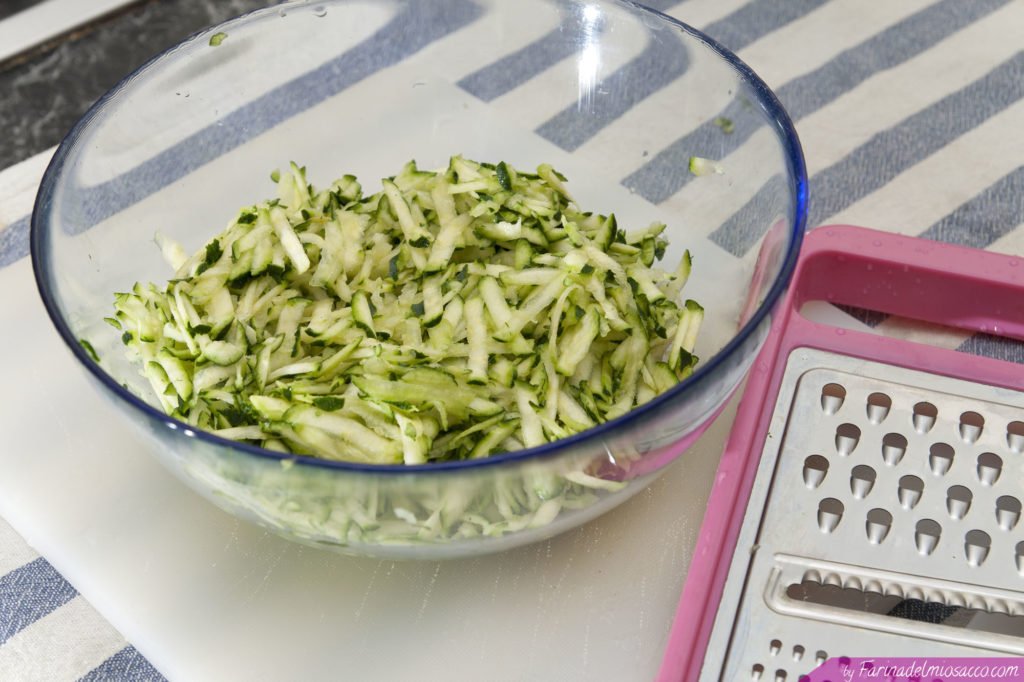 Lavare le zucchine e grattugiare con una grattugia a maglia larga