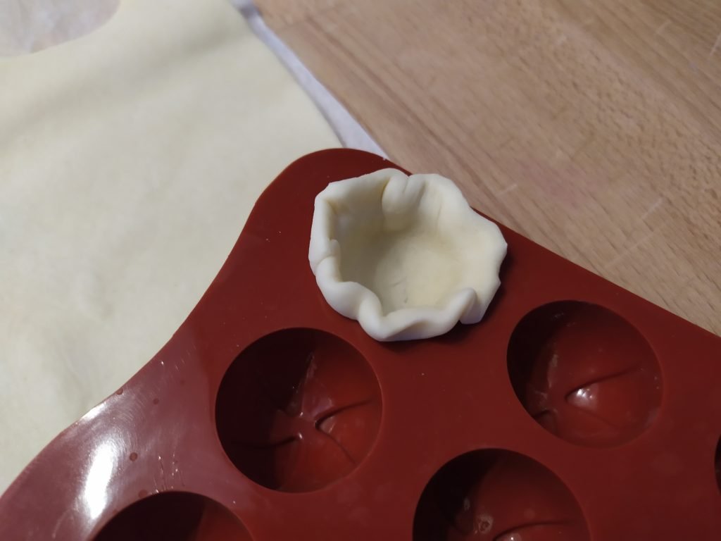 Inseriamo il dischetto di pasta brisèe nello stampo e diamogli la forma con le dita.